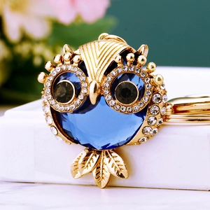 Detail of owl keychain with blue faceted gemstone and sparkling crystal accents