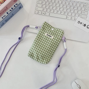 Détail d'une pochette pour téléphone en tissu à carreaux verts avec bandoulière violette