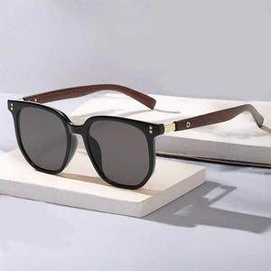Retro polygon sunglasses with black frames and brown wood grain temples on a white stand