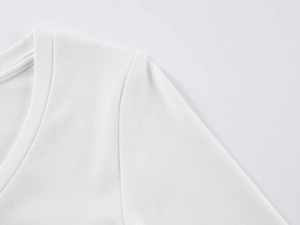 Gros plan d'un t-shirt blanc à col en V montrant les coutures et la maille fine