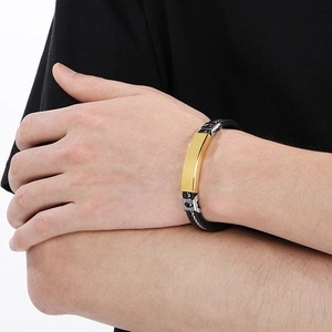 Close-up of men's silicone steel bracelet with a golden rectangular nameplate on wrist