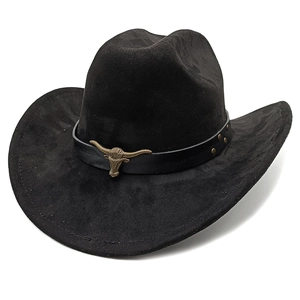 Close-up of black suede cowboy hat with bronze bull head badge and metal rivets