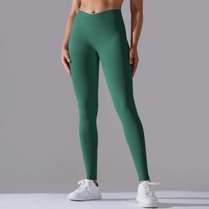 Detail view of the V-cross high waist and ribbed texture on dark green yoga leggings