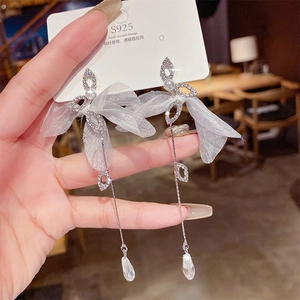 Detail of tassel earrings with lace bow, rhinestones, and teardrop crystals on S925 needles