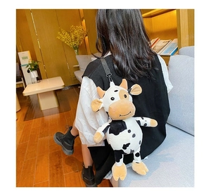 Rear view of a woman wearing the plush cow-shaped crossbody bag in a cozy indoor setting