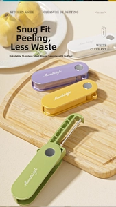 Close-up of four colorful rotating vegetable peelers with stainless steel blades on wood