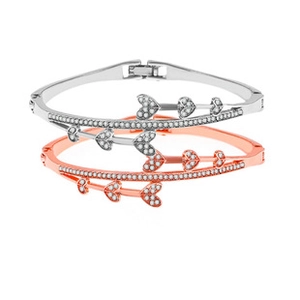 Detail of silver and rose gold metal bracelets with heart and arrow rhinestone charms