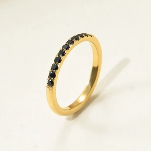 Détail d'une bague en titane doré avec une rangée de spinelles noires serties