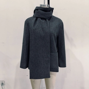 Close-up of a dark grey wool coat featuring a matching scarf and single-breasted buttons
