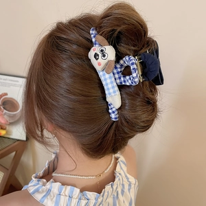 Vue détaillée d'une pince à cheveux à carreaux bleus avec chiot en peluche et nœud
