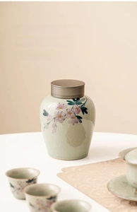 Macro view of hand-painted floral ceramic tea canister with crackle glaze and metal lid