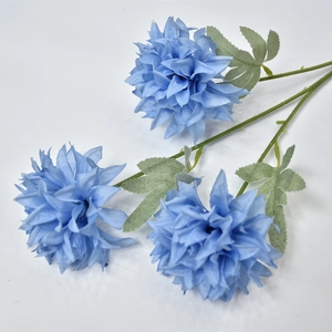 Detail of a blue artificial hydrangea stem with three blooming flower heads and green leaves