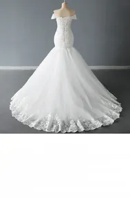 Détail d'une robe de mariée sirène à épaules dénudées avec broderie en dentelle et perles