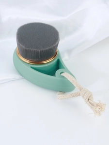 Detail of charcoal face brush bristles with mint green handle and golden metal ring