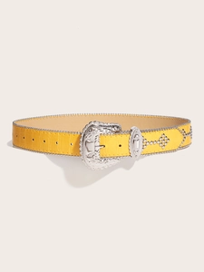 Detail of yellow crocodile pattern leather belt with vintage floral buckle and silver rivets