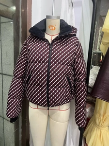 Detail of red and white geometric hooded puffer jacket with black windproof cuffs