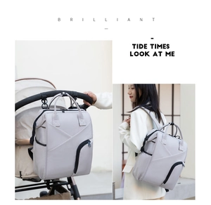 Detail showing multifunctional light gray diaper bag hanging on a stroller with soft fabric