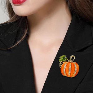 Sparkling Halloween pumpkin brooch with orange enamel and rhinestones on black suit