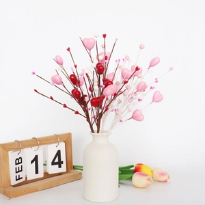 Détail de branches de baies en cœur de Saint-Valentin dans un vase avec calendrier