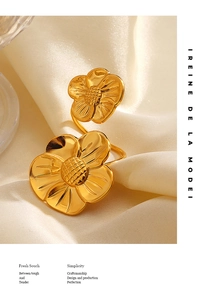 Macro view of golden double flower ring with fine petal textures on cream silk fabric