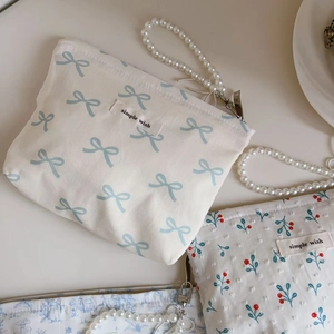 Detailed close-up of cotton mini bags with floral prints and elegant pearl straps