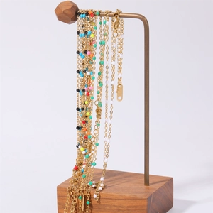 Detail view of Bohemian colorful drip oil stainless steel necklaces on jewelry rack