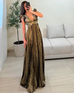 Detail of a deep V-neck metallic pleated maxi dress showing fabric texture and elegant waistline