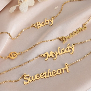 Eleganti collane placcate in oro con scritte Baby e Dreams su seta color champagne