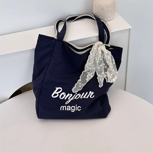 Detail of navy canvas tote bag with Bonjour Magic print and lace scarf detail