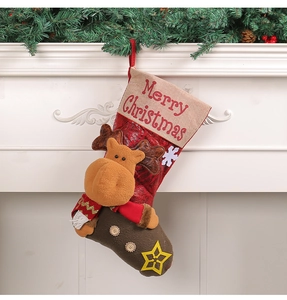 Detail of a thick plush Christmas stocking with a 3D reindeer hanging on a fireplace