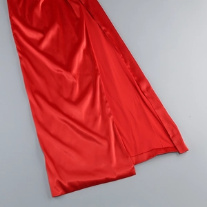 Close-up of elegant red satin evening dress featuring a high side slit and silky texture