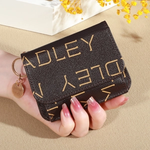 Close-up of brown textured leather wallet with beige letter print and gold pendant decoration