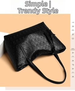 Detail of black leather tote bag with skull pattern embossing and leather tassel fringe