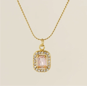 Detail of gold double chain necklace with rectangular pink stone and zircon border