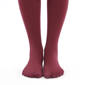 Detail of burgundy thick thermal tights showing smooth matte texture and full foot design
