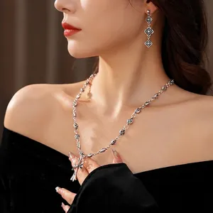 Vintage silver cross pendant necklace and drop earrings set shown on a female model