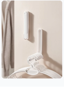 Space-saving folding wall-mounted hanger organizer in white showing folded and unfolded modes