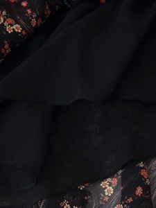 Detailed close-up of floral chiffon fabric with ruffles and a black inner lining