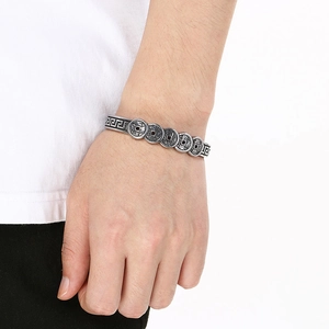 Detailed view of vintage silver steel cuff bracelet with Five Emperor Coins and fret patterns