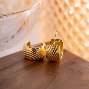 Classic 18K gold-plated stainless steel C-shaped twisted hoop earrings on wooden surface