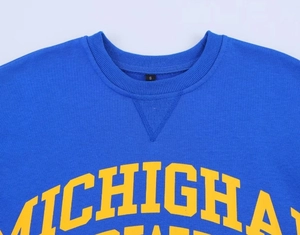 Détail de l'imprimé Michigan sur t-shirt bleu délavé avec col rond et étiquette