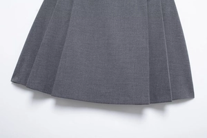 Detailed close-up of pleated hem on dark grey mini skirt showing high-quality fabric texture