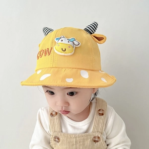 Detail of yellow cotton baby sun hat with cute cow ears and character embroidery