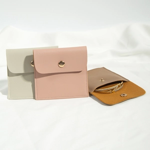Detail of PU leather jewelry pouches with gold snap buttons in pastel green and pink colors