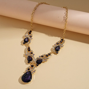 Close-up of gold necklace with water drop purple gemstones and crystal detailing