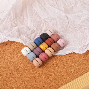 Close-up of colorful magnetic hijab clips in matte finish on natural cork background