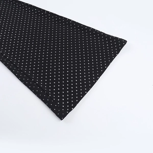 Detailed view of black jumpsuits fabric with silver sequins and high-quality stitching