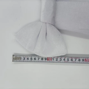 Close-up showing a measuring tape on a 12cm white velvet butterfly wedding decoration