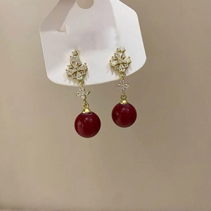 Detail of 18K gold plated long flower earrings with red beads and zircon studs