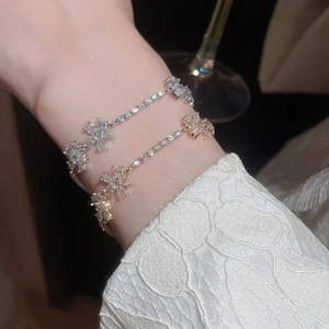 Macro shot of silver and rose gold flower bracelets featuring sparkling zircon stones